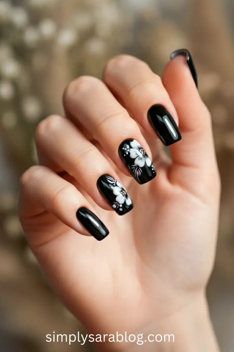 A sleek black spring nail design featuring floral accents and glossy highlights, perfect for a chic and trendy look.